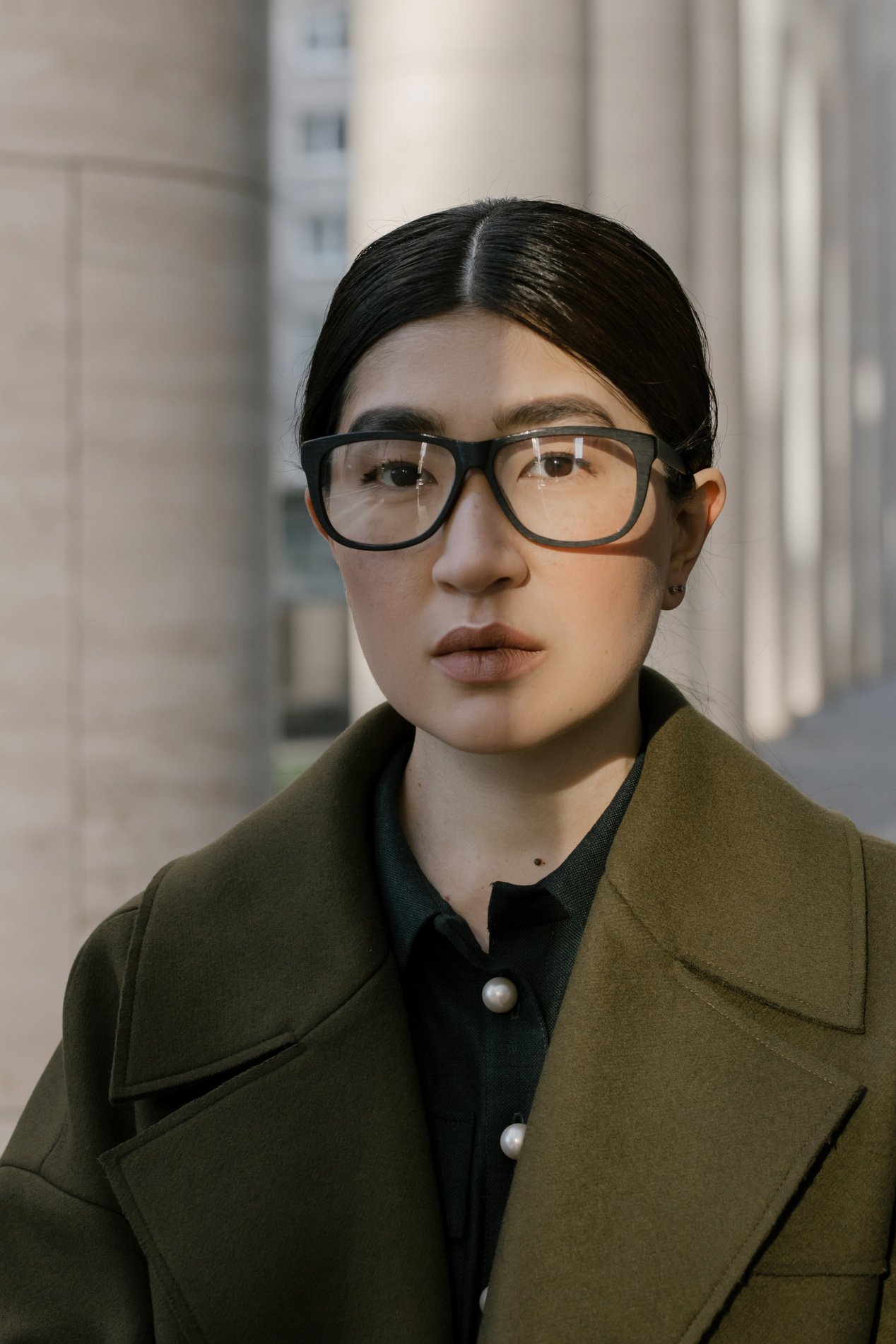 Asian Woman Wearing Brown Coat With Black Framed Eyeglasses